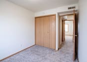 Thumbnail 15 of 28 - A room with a carpeted floor and a wooden door. West Fargo, ND Sheyenne Terrace Townhomes