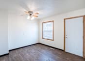 Thumbnail 9 of 28 - A room with a ceiling fan and a door. West Fargo, ND Sheyenne Terrace Townhomes