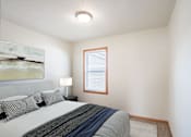 Thumbnail 5 of 28 - A bedroom with a bed, pillows, a lamp, and a painting on the wall. West Fargo, ND Sheyenne Terrace Townhomes
