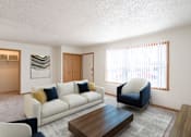 Thumbnail 1 of 28 - A living room with a white couch and a blue chair. West Fargo, ND Sheyenne Terrace Townhomes