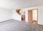 Thumbnail 19 of 28 - A room with a carpeted floor and a staircase. West Fargo, ND Sheyenne Terrace Townhomes