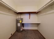 Thumbnail 8 of 10 - a small room with shelves and a water heater. Fargo, ND Alden Pines Apartments.