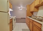 Thumbnail 4 of 10 - a kitchen with a stove refrigerator and sink. Fargo, ND Alden Pines Apartments