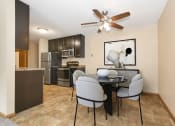 Thumbnail 5 of 29 - a dining area with a table and chairs and a kitchen with stainless steel appliances. Anoka, MN Dellwood Estates
