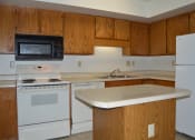 Thumbnail 3 of 6 - a kitchen with white appliances and wooden cabinets