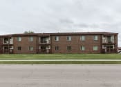 Thumbnail 6 of 7 - Grand Forks, ND Barrette Arms Apartments. a large brick apartment building with balconies