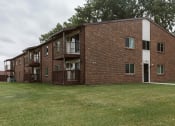 Thumbnail 7 of 7 - Grand Forks, ND Barrette Arms Apartments. a large brick apartment building with a large grassy area in front of it