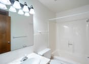 Thumbnail 24 of 25 - a white bathroom with a tub and a sink and a mirror. Fargo, ND Betty Ann Apartments