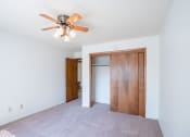 Thumbnail 22 of 25 - a bedroom with a ceiling fan and a closet. Fargo, ND Betty Ann Apartments
