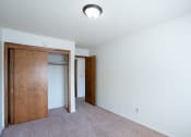 Thumbnail 20 of 25 - an empty room with a closet and a door to a bedroom. Fargo, ND Betty Ann Apartments