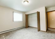 Thumbnail 10 of 17 - Grand Forks, ND Grandview II Apartments. A bedroom with a window and closet.