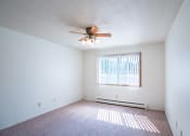 Thumbnail 21 of 25 - a bedroom with a ceiling fan and a window. Fargo, ND Betty Ann Apartments