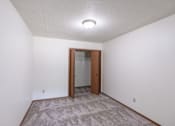 Thumbnail 17 of 19 - a room with a carpeted floor and a door to a closet. Fargo, ND Rosegate Apartments