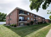 Thumbnail 25 of 25 - a red brick apartment building with a green lawn and a sidewalk. Fargo, ND Betty Ann Apartments