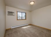 Thumbnail 6 of 16 - a bedroom with a window and a carpeted floor. Fargo, ND Birchwood 2 Apartments