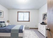 Thumbnail 4 of 6 - Bismarck, ND Arbor apartments. a bedroom with a bed and a dresser