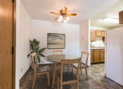 Thumbnail 2 of 6 - Bismarck, ND Arbor apartments. a dining area with a table and chairs and a kitchen in the background