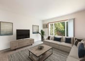 Thumbnail 1 of 7 - Bismarck, ND Bradbury Apartments. a living room with a couch and coffee table and a large window