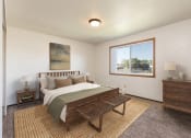Thumbnail 2 of 6 - Bismarck, ND Brentwood II Apartments. A bedroom with a large bed and a large window