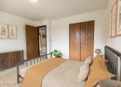 Thumbnail 3 of 14 - Bismarck, ND Eagle Sky I. A bedroom with a bed and a wardrobe. The yellow accents on the bed make for a bright energetic room.