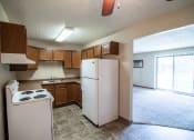 Thumbnail 7 of 16 - Bismarck, ND Eastbrook Apartments | a kitchen with white appliances and brown cabinets