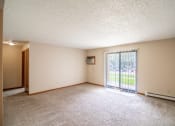 Thumbnail 8 of 16 - Bismarck, ND Eastbrook Apartments. A spacious living room with a sliding glass door leading to a yard