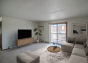 Thumbnail 4 of 16 - A living room with a couch and a coffee table. Bismarck, ND Eastbrook Apartments.