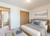 Thumbnail 4 of 11 - Bismarck Pebble Creek Apartments bedroom. The room features modern furnishings, soft lighting, and a comfortable bed. Theres a closet in the corner of the room for storage or clothing.
