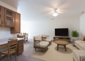 Thumbnail 2 of 11 - Bismarck Pebble Creek Apartments. The spacious living room is tastefully decorated with stylish furniture, ample natural light, and a cozy atmosphere. Theres overhead lighting with a touch of natural light from the dining room.