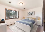 Thumbnail 5 of 10 - Bismarck, ND Riverpark Apartments  a bedroom with a large window and a large bed with blue bedding