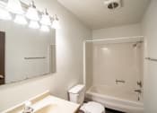 Thumbnail 14 of 17 - Bismarck, ND Rosser Apartments. a bathroom with a bathtub and a sink