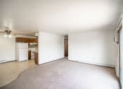 Thumbnail 17 of 17 - Bismarck, ND Rosser Apartments. an empty living room with a kitchen in the background