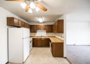Thumbnail 16 of 17 - Bismarck, ND Rosser Apartments. a kitchen with a white refrigerator freezer next to a stove top oven
