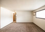 Thumbnail 7 of 17 - Bismarck, ND Rosser Apartments. an empty room with carpet and a large window