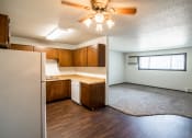 Thumbnail 9 of 17 - Bismarck, ND Rosser Apartments. a kitchen and living room with a ceiling fan