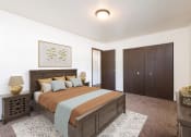 Thumbnail 5 of 17 - Bismarck, ND Rosser Apartments. A bedroom with a large bed and a closet.