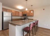 Thumbnail 6 of 16 - Kitchen with Breakfast Bar at Stonefield Apartments in Bismarck, ND