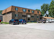 Thumbnail 6 of 6 - A parking lot in front of a building with cars parked. Bismarck, ND Arbor 406 Apartments