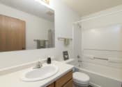Thumbnail 7 of 7 - a bathroom with a sink and a toilet and a shower. Bismarck, ND Bradbury Apartments