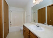 Thumbnail 23 of 26 - a bathroom with a sink and a toilet and a shower. Fargo, ND Bridgeport Apartments