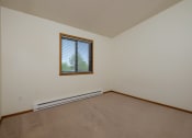 Thumbnail 21 of 26 - a bedroom with a window and baseboard heater. Fargo, ND Bridgeport Apartments