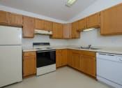 Thumbnail 20 of 26 - a kitchen with white appliances and wooden cabinets. Fargo, ND Bridgeport Apartments