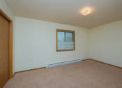 Thumbnail 16 of 26 - a bedroom with a window and a carpeted floor. Fargo, ND Bridgeport Apartments