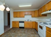 Thumbnail 14 of 26 - a kitchen with white appliances and wooden cabinets. Fargo, ND Bridgeport Apartments