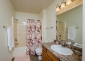 Thumbnail 12 of 26 - a bathroom with a sink and a toilet and a shower. Fargo, ND Bridgeport Apartments