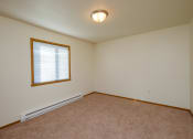 Thumbnail 9 of 26 - a bedroom with a window and a carpeted floor. Fargo, ND Bridgeport Apartments