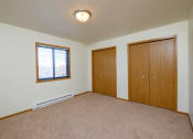 Thumbnail 11 of 26 - a  bedroom with two closets and a window. Fargo, ND Bridgeport Apartments