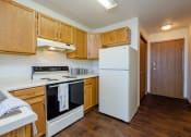 Thumbnail 24 of 26 - a kitchen with white appliances in an efficiency apartment. Fargo, ND Bridgeport Apartments