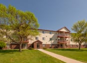 Thumbnail 25 of 26 - the outside of an apartment building with three levels and two trees. Fargo, ND Bridgeport Apartments