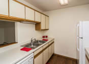 Thumbnail 9 of 19 - Grand Forks, ND Bristol Park Apartments. a kitchen with white appliances and wooden cabinets